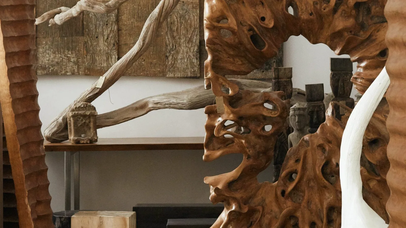Teak root mirror, driftwood and carved wall panels in the Andrianna Shamaris gallery